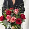 Rosenzauber Rote und rosafarbene Rosen mit feinen Gräsern und ausgewähltem Grün.