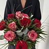 Rosenzauber Rote und rosafarbene Rosen mit feinen Gräsern und ausgewähltem Grün.