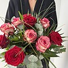 Rosenzauber Rote und rosafarbene Rosen mit feinen Gräsern und ausgewähltem Grün.