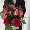 Rosenzauber Rote und rosafarbene Rosen mit feinen Gräsern und ausgewähltem Grün.