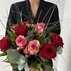 Rosenzauber Rote und rosafarbene Rosen mit feinen Gräsern und ausgewähltem Grün.